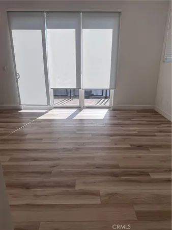 a view of empty room with window and wooden floor
