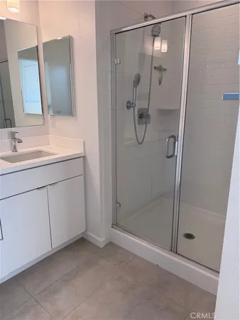 a bathroom with a shower sink and mirror