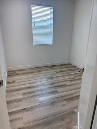 a view of a room with wooden floor and a window