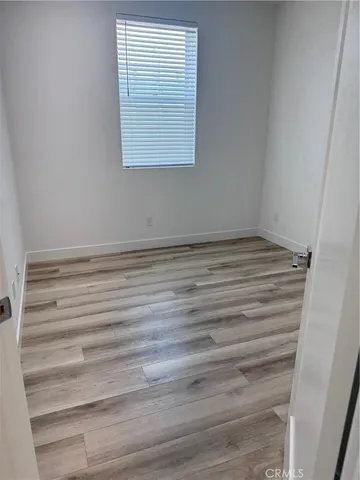 a view of a room with wooden floor and a window