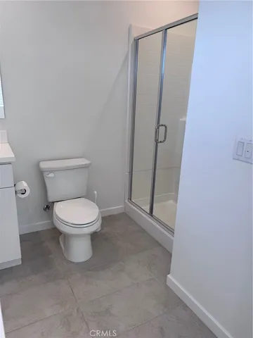 a white toilet sitting next to a shower