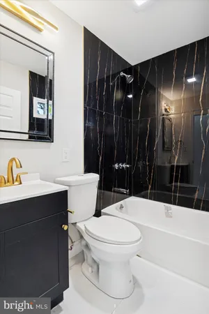 a bathroom with a sink a toilet a mirror and shower