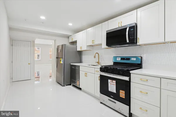 a kitchen with stainless steel appliances a white stove top oven microwave and cabinets
