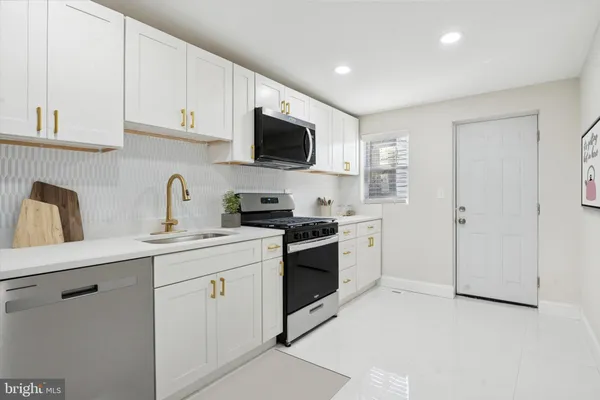 a kitchen with white cabinets and white appliances