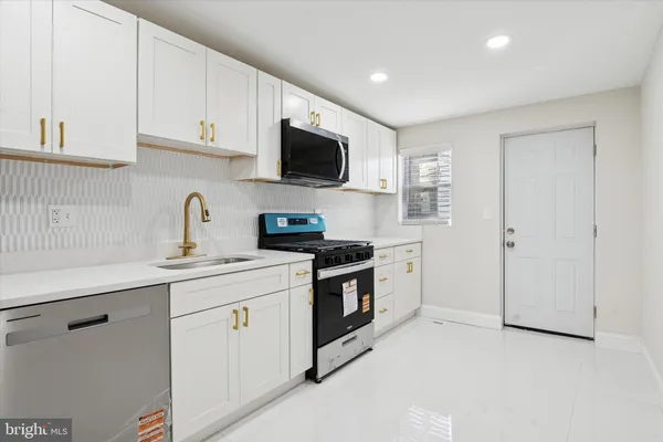 a kitchen with white cabinets stainless steel appliances and sink