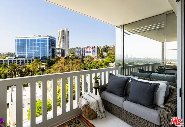 a balcony with furniture and a potted plant