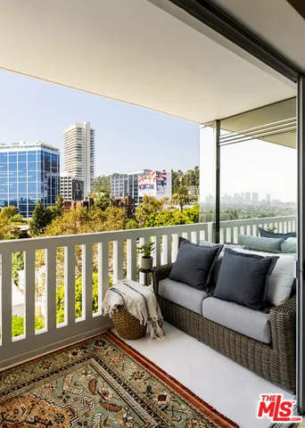 a balcony with furniture and a floor to ceiling window