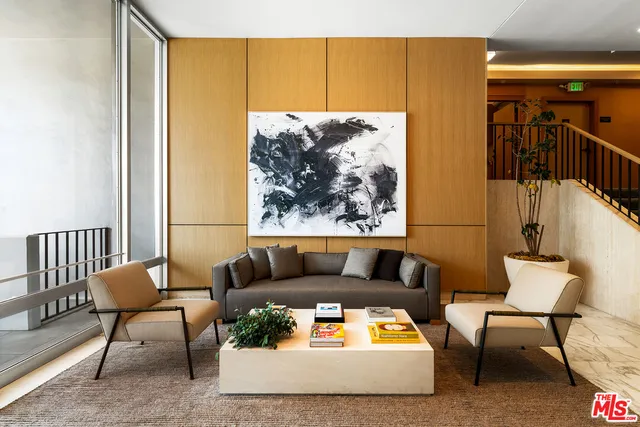 a living room with furniture and a painting on the wall