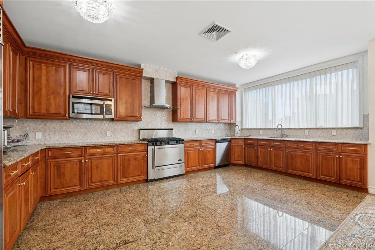 99-31 66th Avenue, Unit 7B Queens, NY 11374 - Photo 11 of 26 a large kitchen with stainless steel appliances granite countertop wooden cabinets a stove a sink and a window