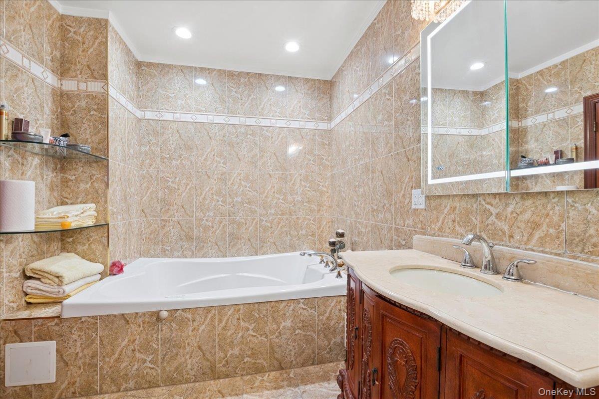 99-31 66th Avenue, Unit 7B Queens, NY 11374 - Photo 16 of 26 a bathroom with a tub sink and mirror
