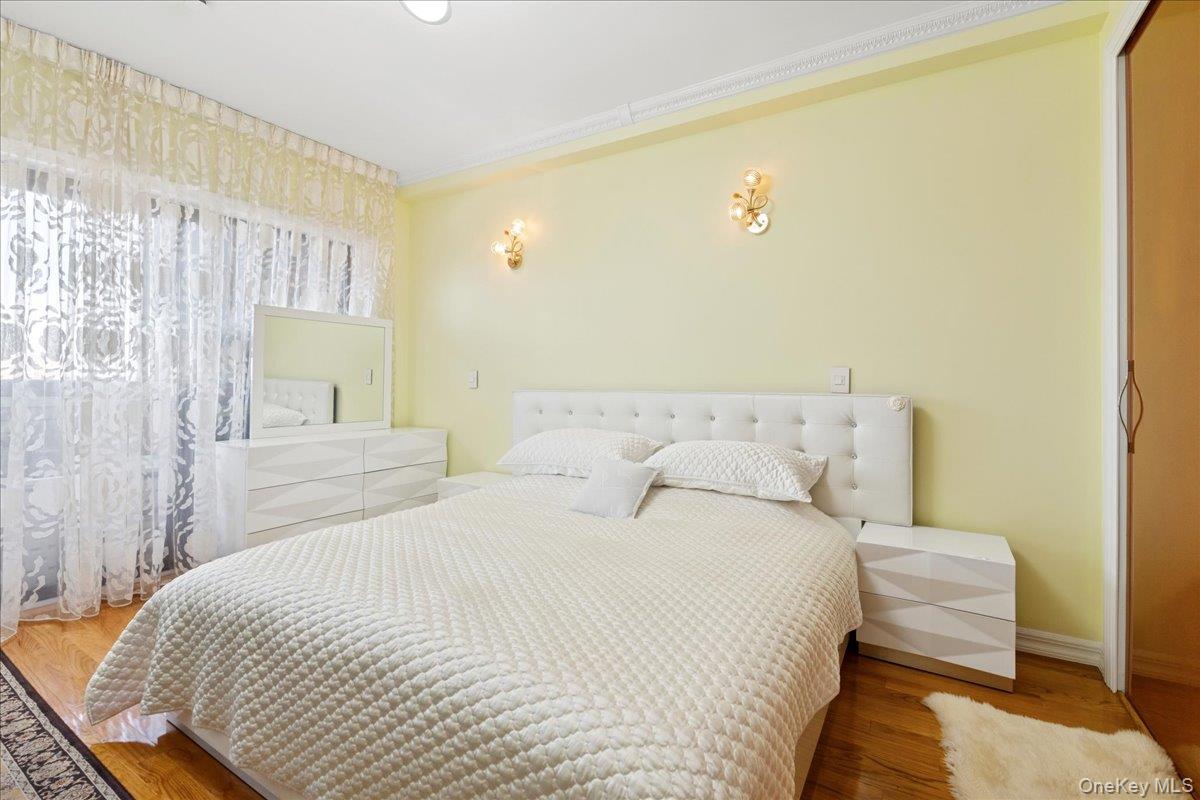 99-31 66th Avenue, Unit 7B Queens, NY 11374 - Photo 17 of 26 a bedroom with a bed and a couch