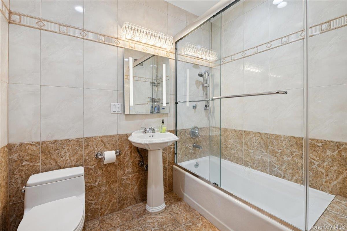 99-31 66th Avenue, Unit 7B Queens, NY 11374 - Photo 20 of 26 a bath room with a bath tub and a shower