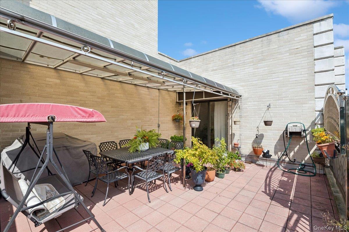 99-31 66th Avenue, Unit 7B Queens, NY 11374 - Photo 26 of 26 a view of a patio with table and chairs under an umbrella