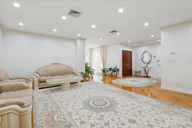 a living room with furniture a table and wooden floor