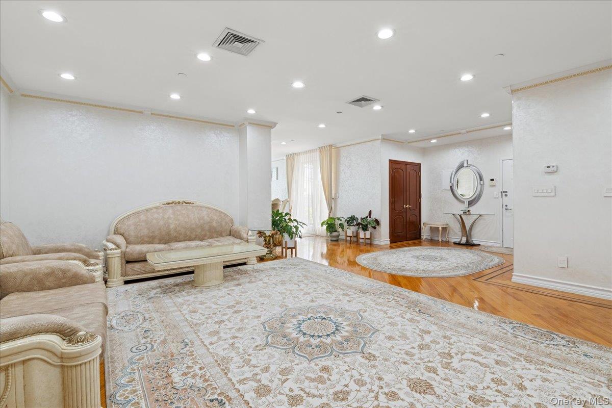 99-31 66th Avenue, Unit 7B Queens, NY 11374 - Photo 4 of 26 a living room with furniture a table and wooden floor