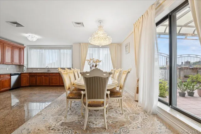 a view of a dining room with furniture a chandelier and wooden floor