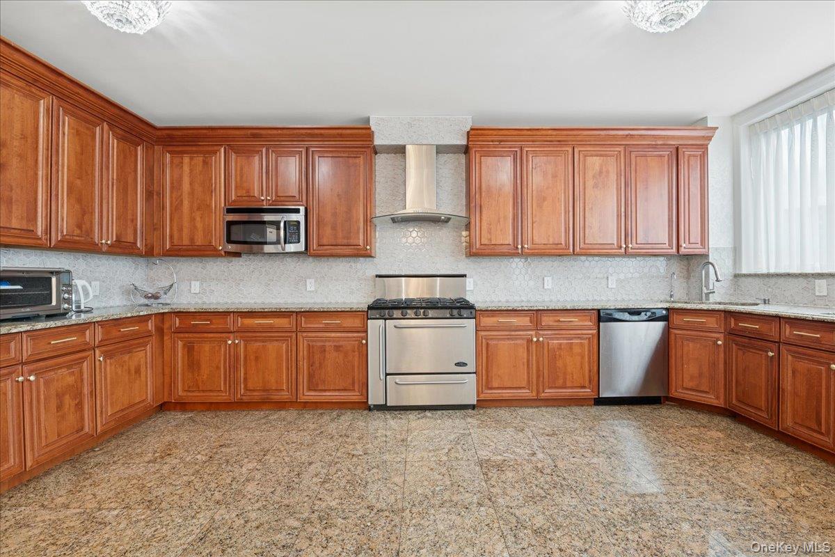99-31 66th Avenue, Unit 7B Queens, NY 11374 - Photo 9 of 26 a kitchen with stainless steel appliances granite countertop a stove a sink dishwasher and a microwave oven with cabinets