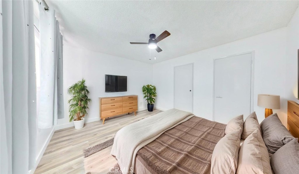 1648 Vía Mirada, Unit B Fullerton, CA 92833 - Photo 11 of 30 a bedroom with a large bed and a tv