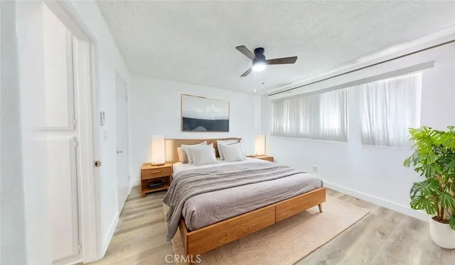 a bedroom with a bed chandelier and a window
