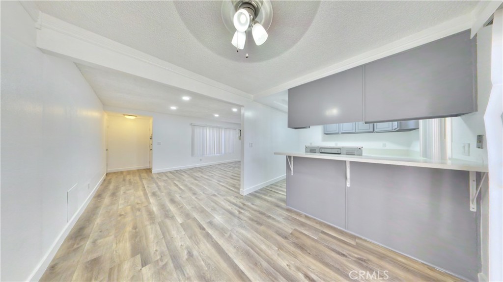 1648 Vía Mirada, Unit B Fullerton, CA 92833 - Photo 23 of 30 a view of an empty room and kitchen view with wooden floor