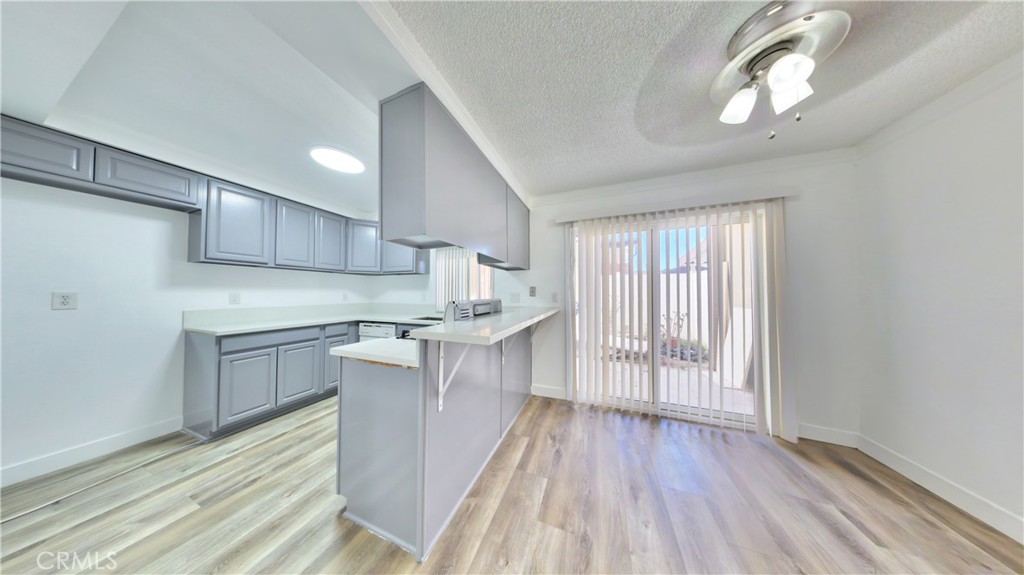 1648 Vía Mirada, Unit B Fullerton, CA 92833 - Photo 24 of 30 a kitchen with wooden floors and white cabinets
