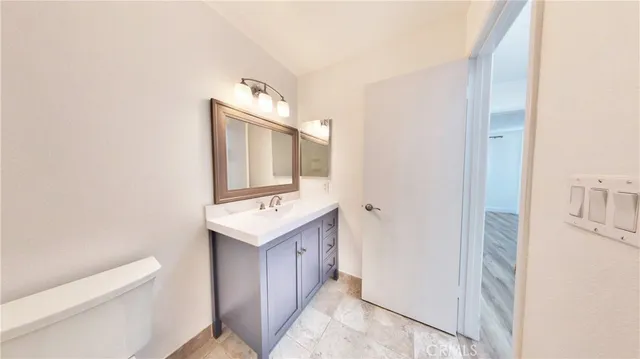 a bathroom with a sink a toilet and mirror