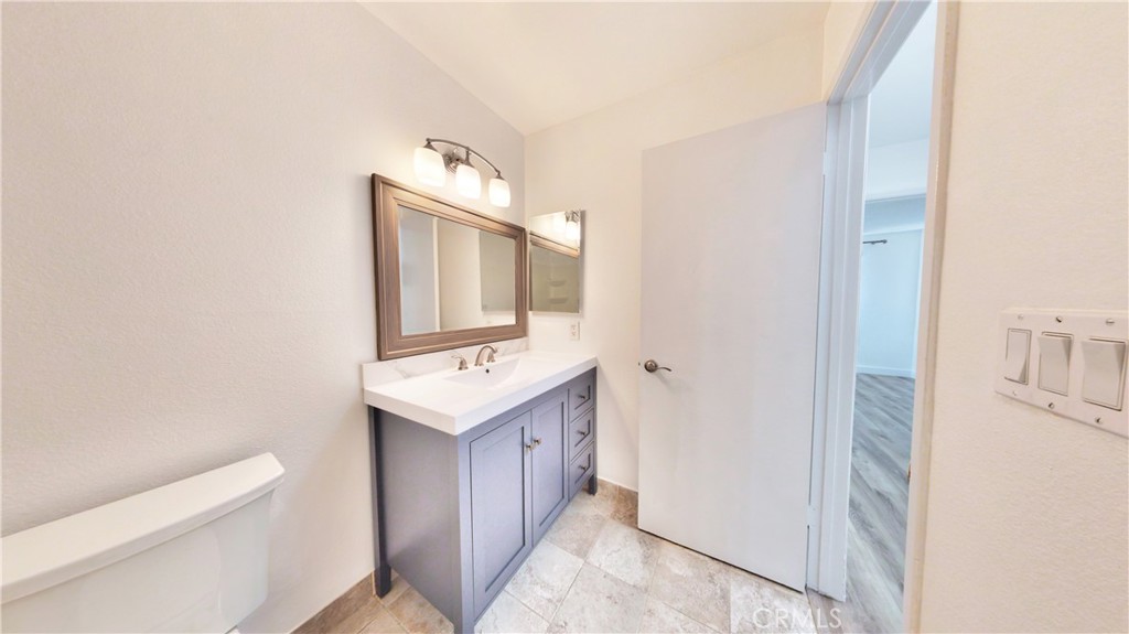 1648 Vía Mirada, Unit B Fullerton, CA 92833 - Photo 26 of 30 a bathroom with a sink a toilet and mirror