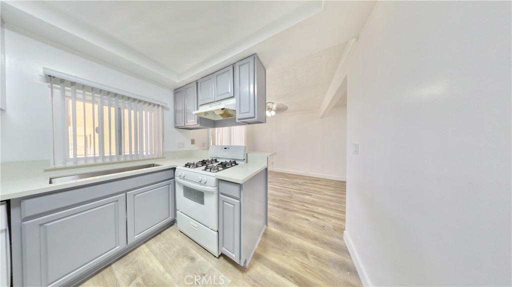1648 Vía Mirada, Unit B Fullerton, CA 92833 - Photo 6 of 30 a kitchen with granite countertop white cabinets and white appliances