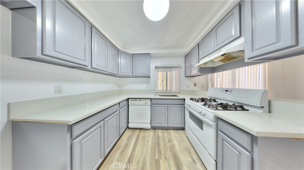 1648 Vía Mirada, Unit B Fullerton, CA 92833 - Photo 7 of 30 a kitchen with granite countertop a sink a stove cabinets and wooden floor