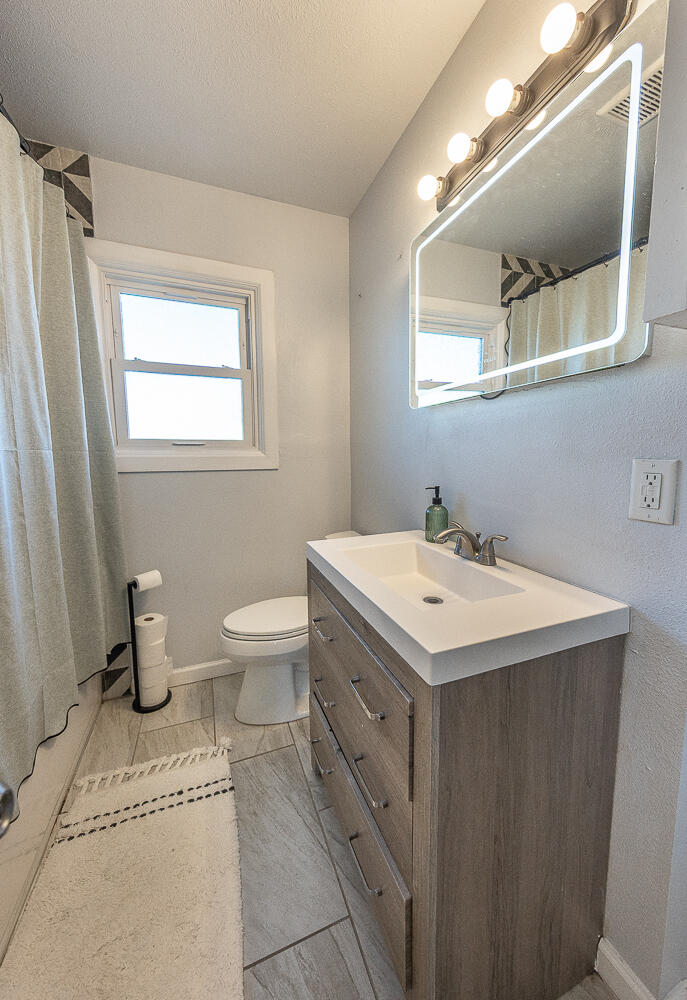 5109 44th Street Lubbock, TX 79414 - Photo 14 of 20 a bathroom with a sink toilet and mirror