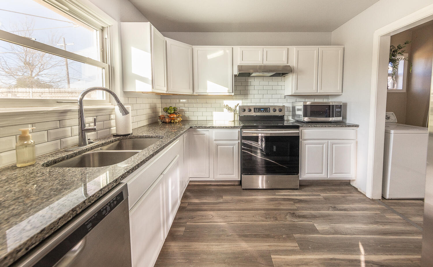 5109 44th Street Lubbock, TX 79414 - Photo 3 of 20 a kitchen with a stove sink and cabinets
