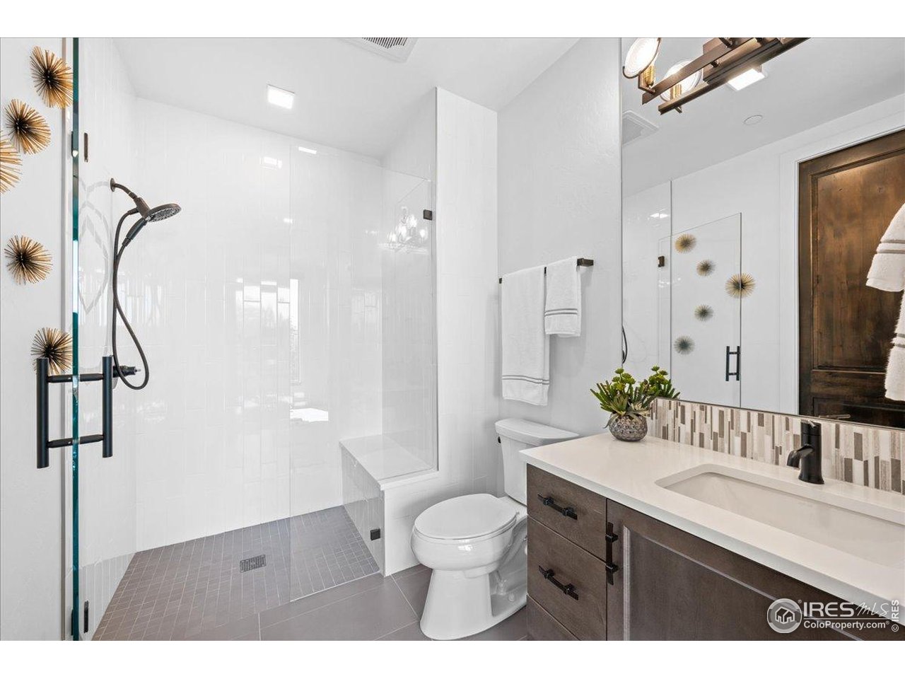 302 North Meldrum Street, Unit 313 Fort Collins, CO 80521 - Photo 20 of 38 a bathroom with a granite countertop sink toilet a mirror and shower