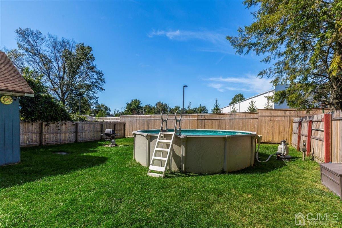 284 Old Post Road Edison, NJ 08817 - Photo 21 of 27 a view of a backyard with wooden fence and a large tree