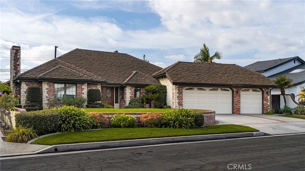 Charming Brick Exterior with Beautiful Landscaping and Three-Car Garage