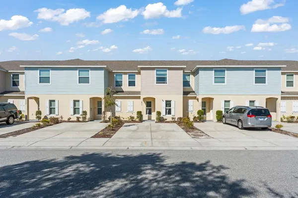 a view of a patio with cars parked front of the house