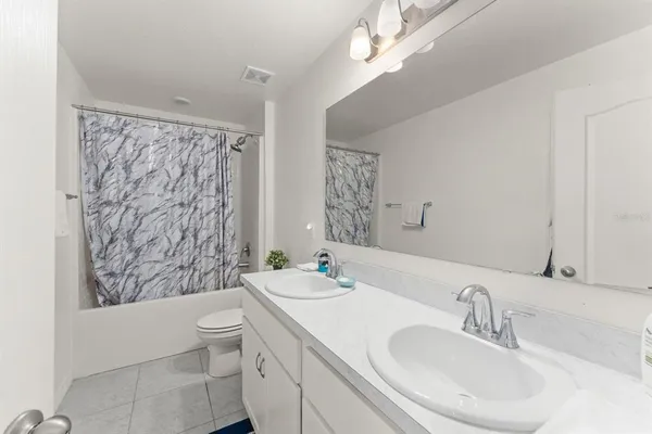 a bathroom with a sink a toilet a mirror a vanity and shower