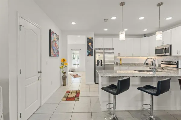 a kitchen with cabinets and chairs