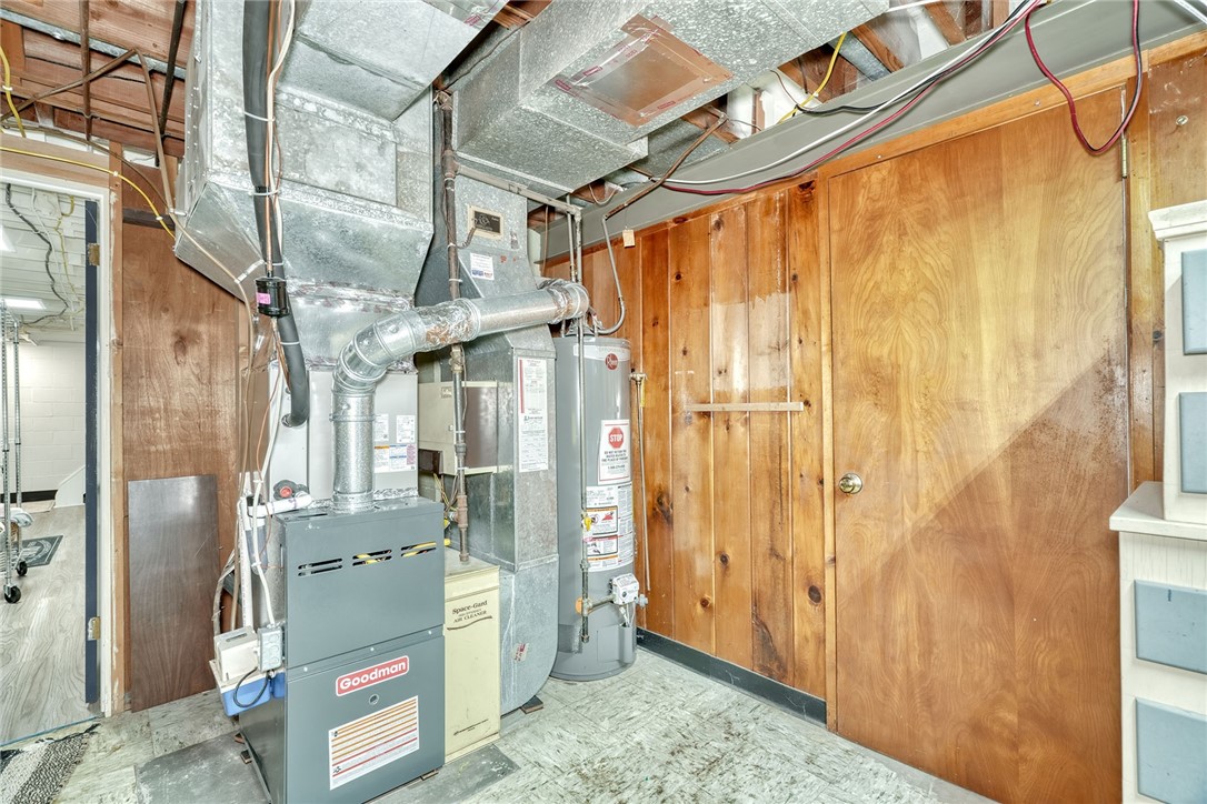 255 Fairport Road East Rochester, NY 14445 - Photo 23 of 26 A functional utility area features wood paneling and exposed ceiling joists.
