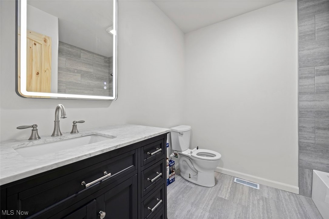 1515 Butler Road New London, OH 44851 - Photo 24 of 39 Full bathroom featuring vanity, wood finished floors, and a bathtub