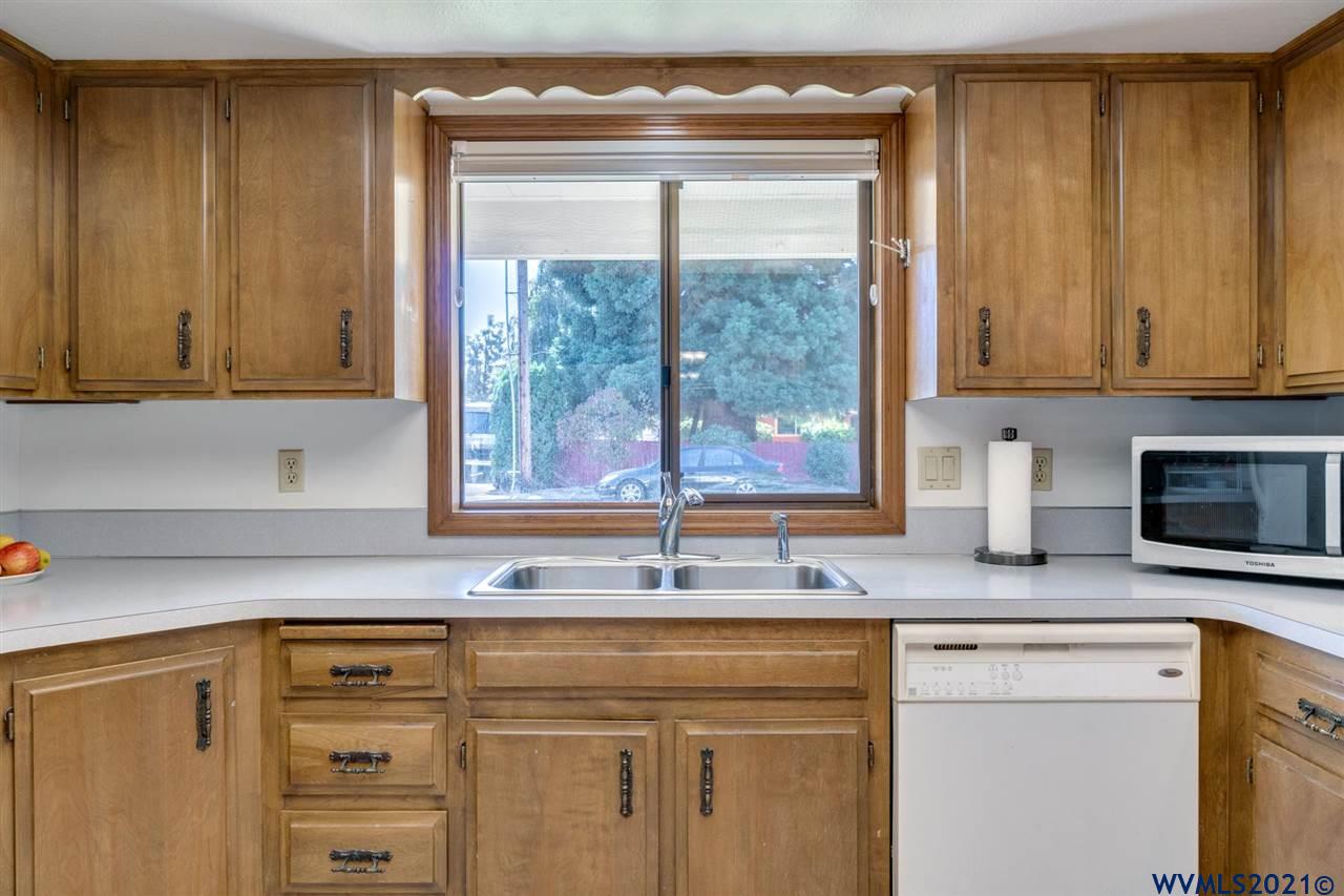 4695 Herrin Road Northeast Salem, OR 97305 - Photo 13 of 32 a kitchen with granite countertop cabinets stainless steel appliances a sink and a window