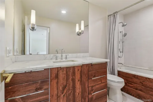a bathroom with a granite countertop sink toilet and shower