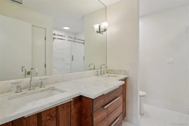 a bathroom with a granite countertop sink a toilet and a mirror