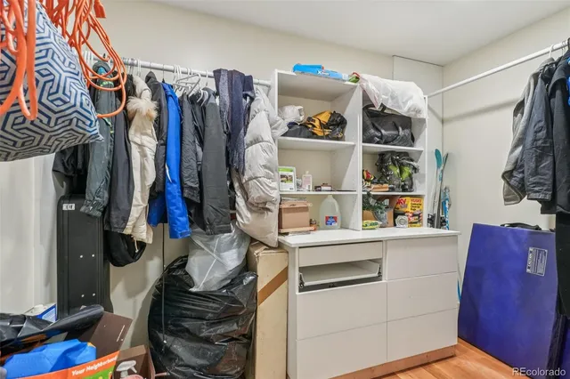 a view of walk in closet with clothes and shoes