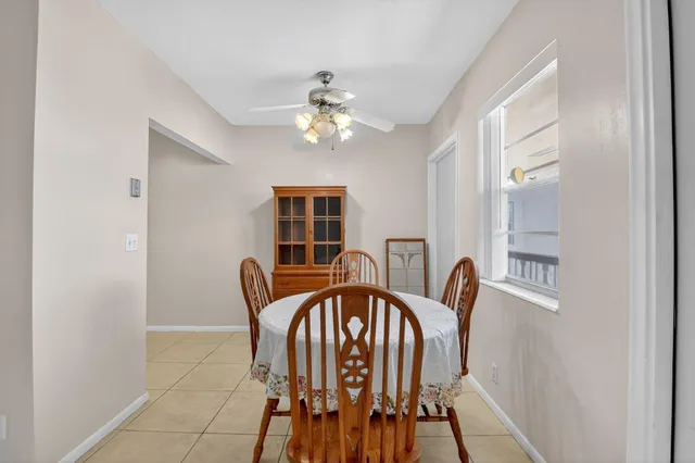 a view of a dining room with furniture and chandelier fan