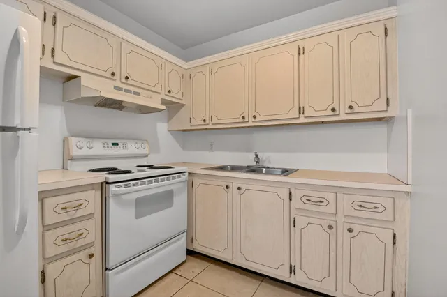 a kitchen with white cabinets and white appliances