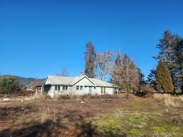 a view of a house with a yard and sitting area