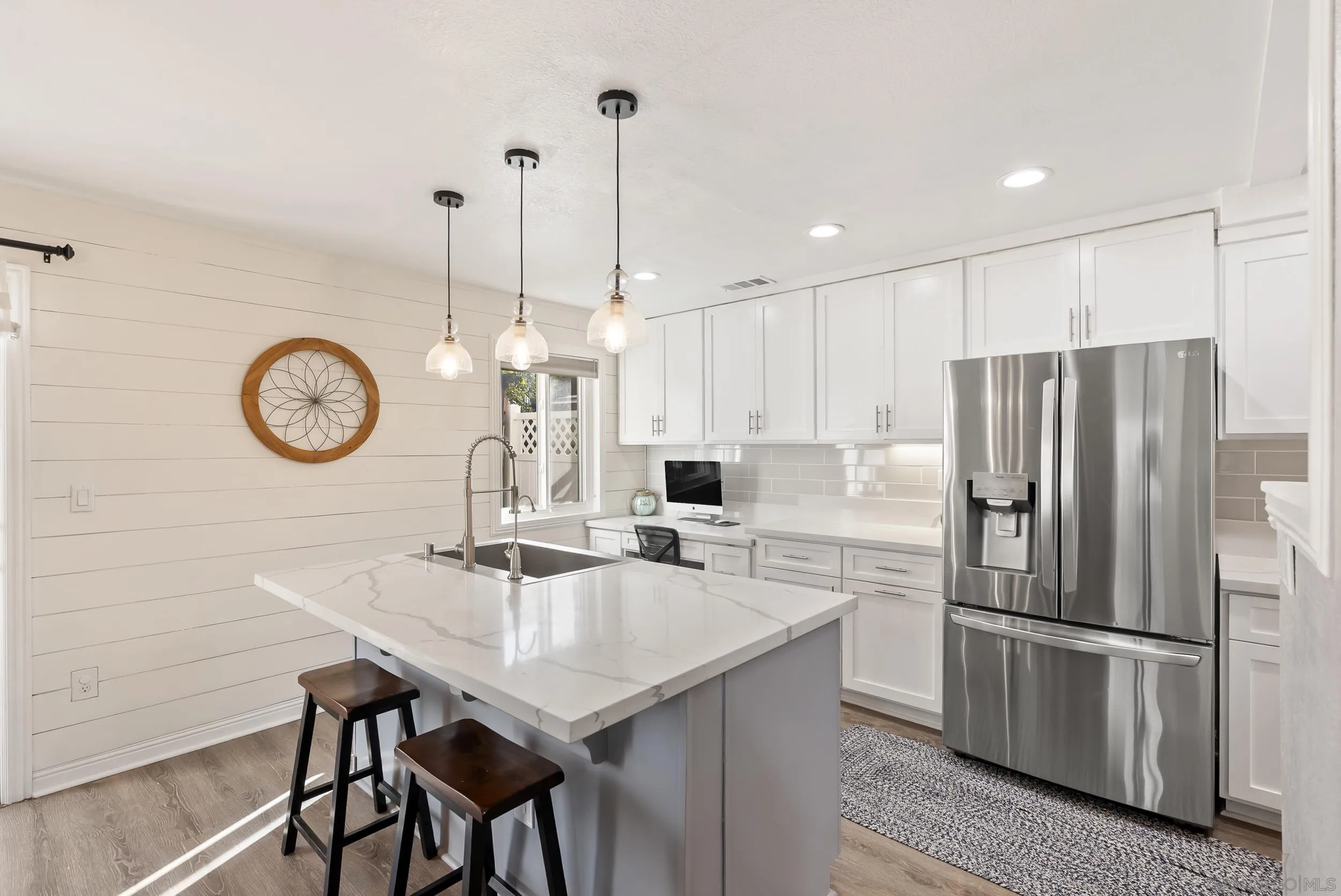 a kitchen with stainless steel appliances granite countertop a sink a refrigerator a dining table and chairs