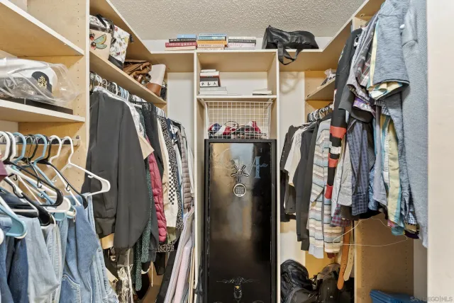 a view of walk in closet with clothes