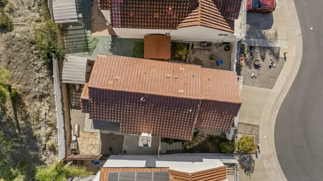 an aerial view of residential house with outdoor space and trees all around