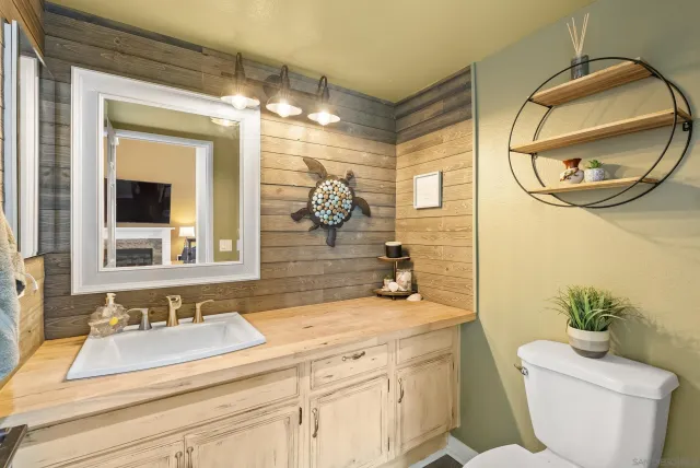 a bathroom with a granite countertop sink mirror and toilet